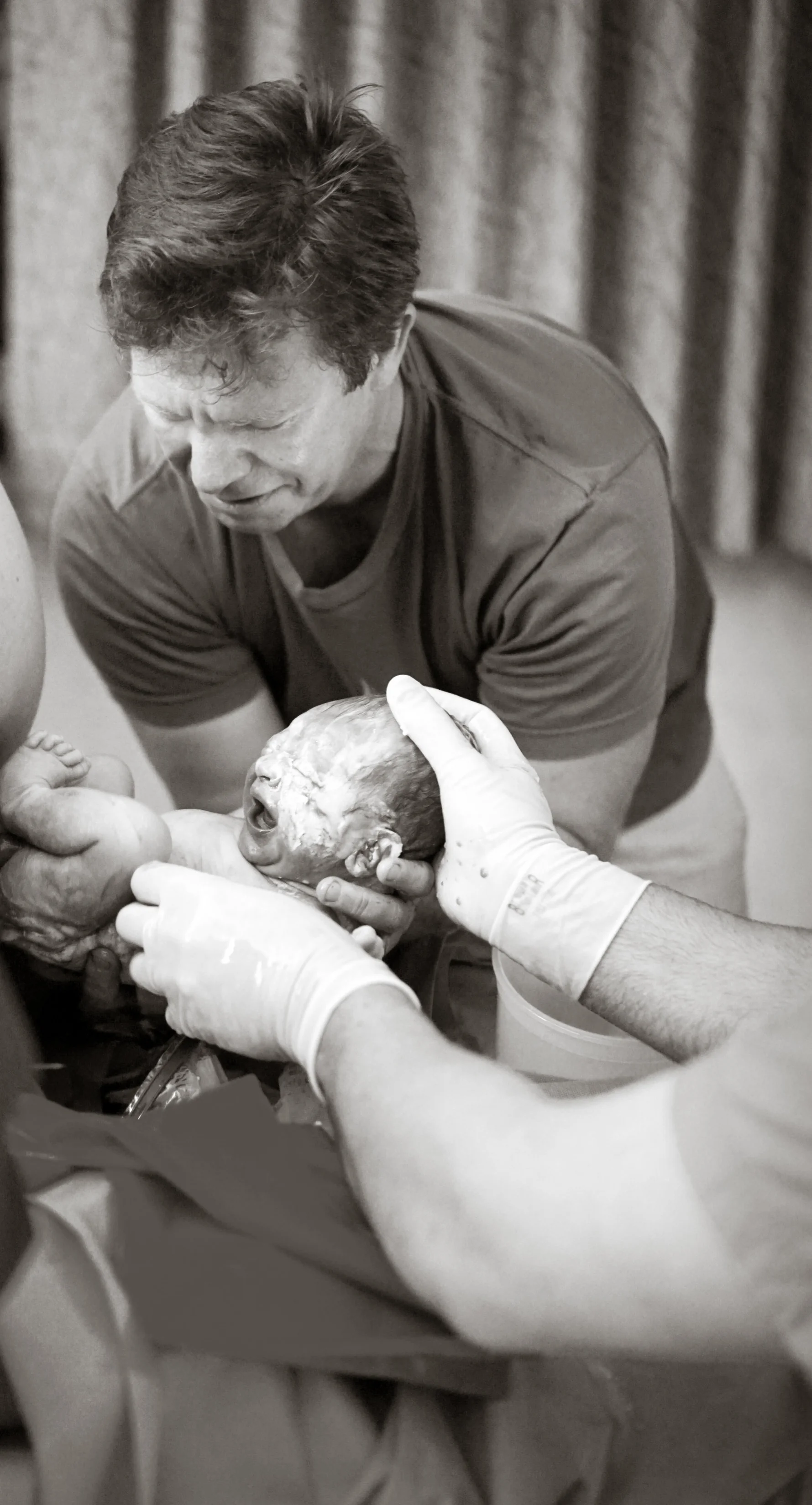 My husband, receiving our baby with a little help from Dr. Cap!
