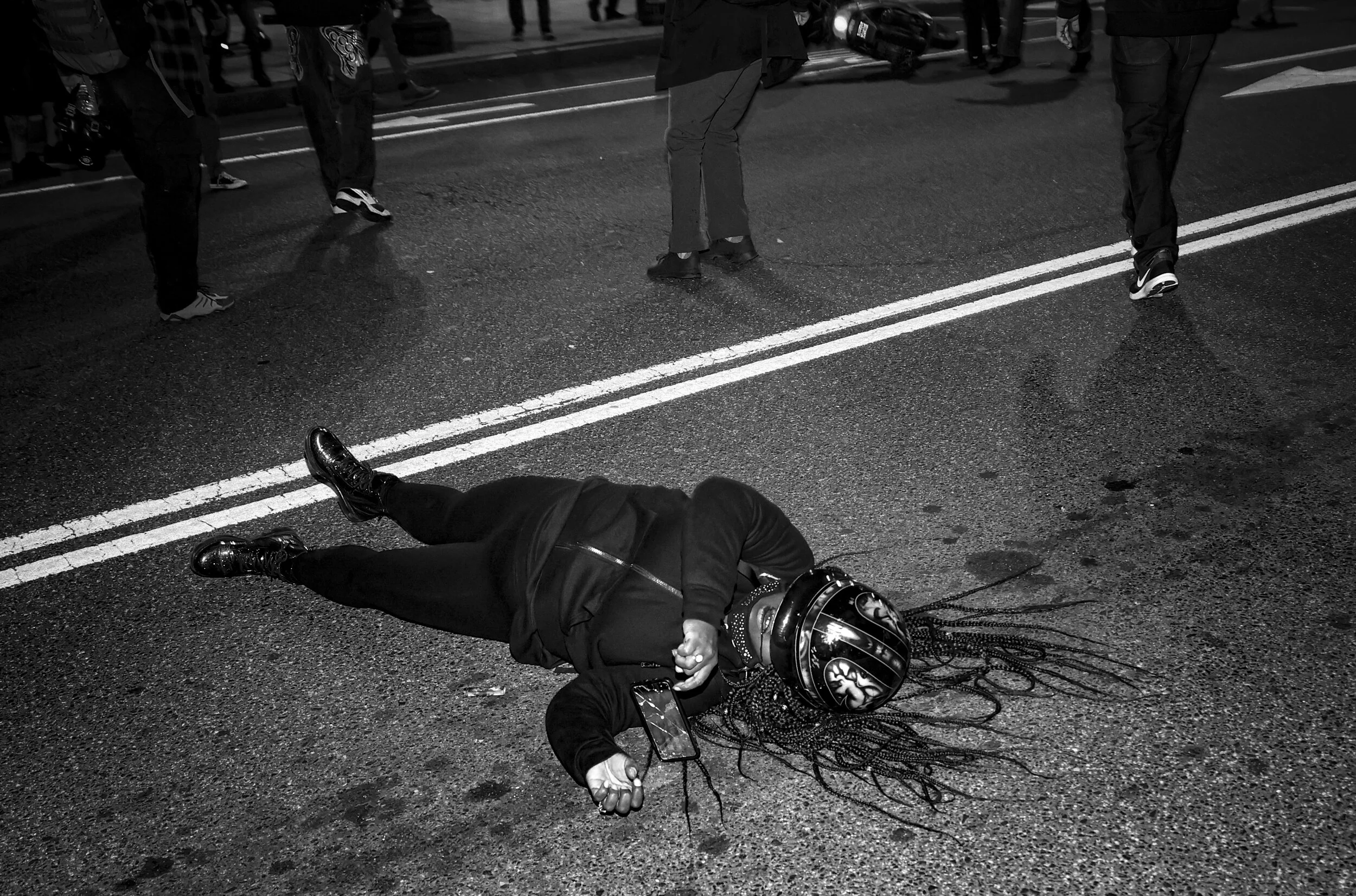 A protester bleeds from the mouth as she lays in the middle of the street during a protest following the “Million MAGA March” from Freedom Plaza to the Supreme Court, on November 14, 2020 in Washington, DC. (Photo by Tasos Katopodis/Getty Images)