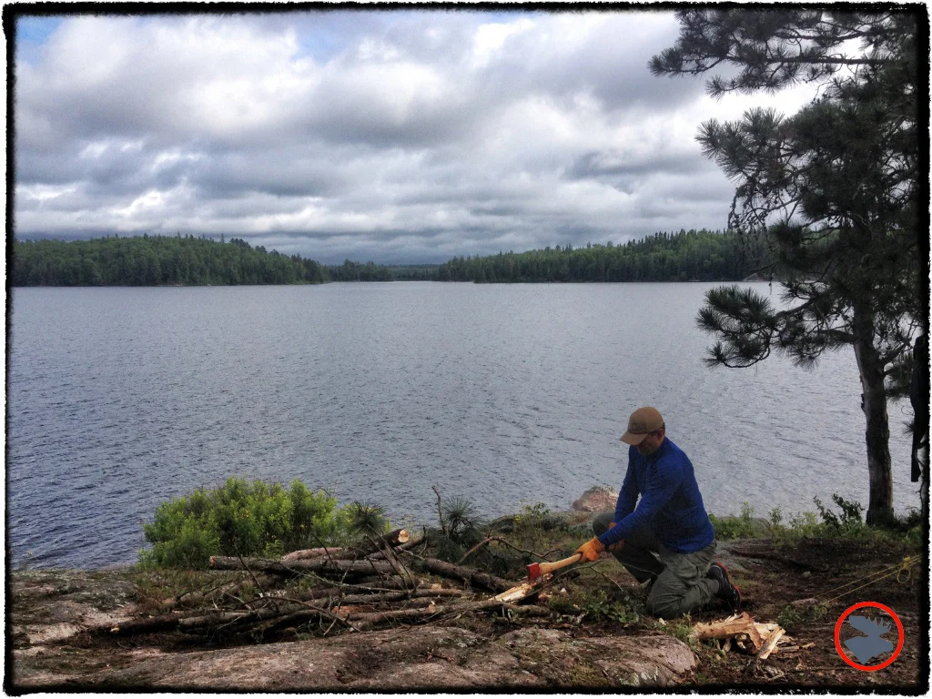 Bartek practicing safe axe handling and splitting wood to feed the fire.