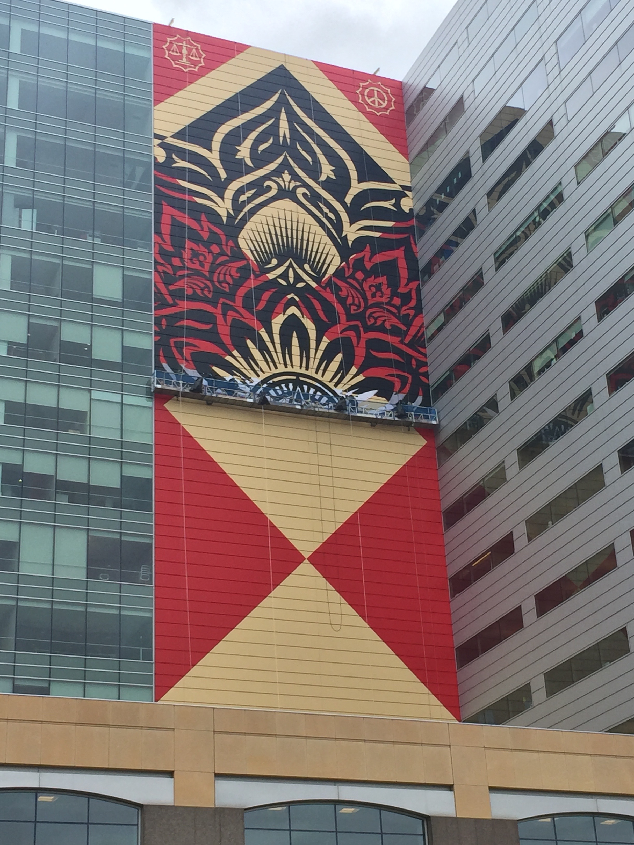 Shepherd Fairey works on a new mural on the side of One Campus Martius. 