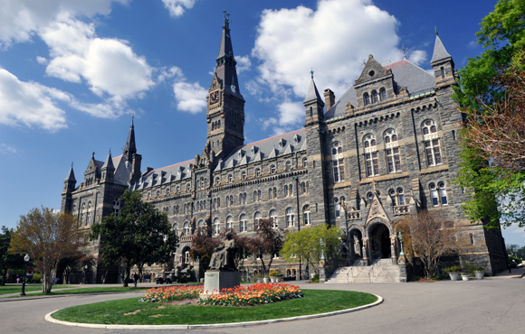 Washington, D.C., USA - April 9, 2012. Healy Hall with the statue of Georgetown University founder John Carroll in front and some people walking in background. Georgetown University is a top-ranking private university in the United States. It is located in the historic district of Georgetown in Northwest Washington, D.C.