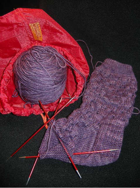 Modern sockmaking accouterments de rigeur : Go Knit pouch (sock people walk while knitting), Signature DPNs (size 2, 6" length) and Socks That Rock Lightweight in Tanzanite (Pattern I made up and am unlikely to remember for the 2nd sock) All the cool kids have these things, and they really make it fun.