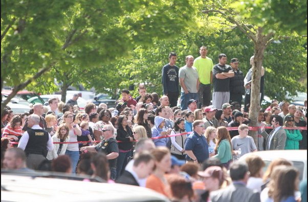 Some parents climbed up onto a dumpster, trying to see better if anything was happening in the parking lot. It wasn't.