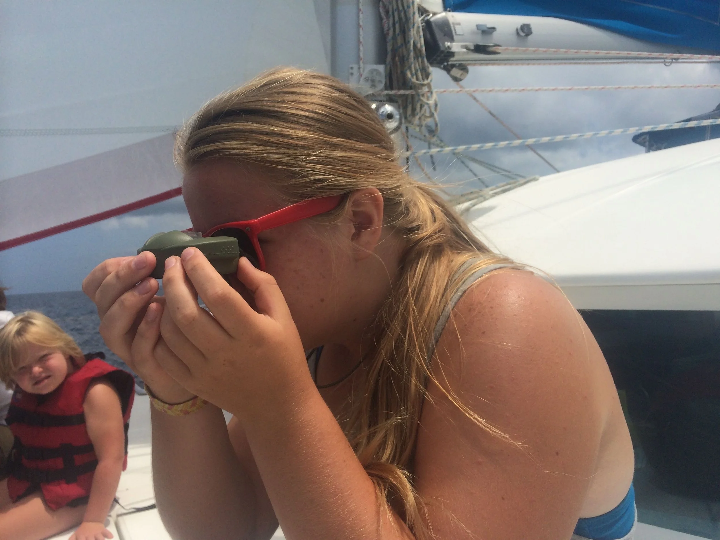 Karina taking a bearing with a handheld compass.
