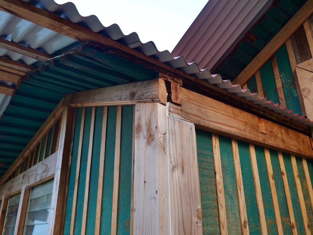 Single wall construction: tongue and groove walls with cedar strips covering the seams, and a tin roof.