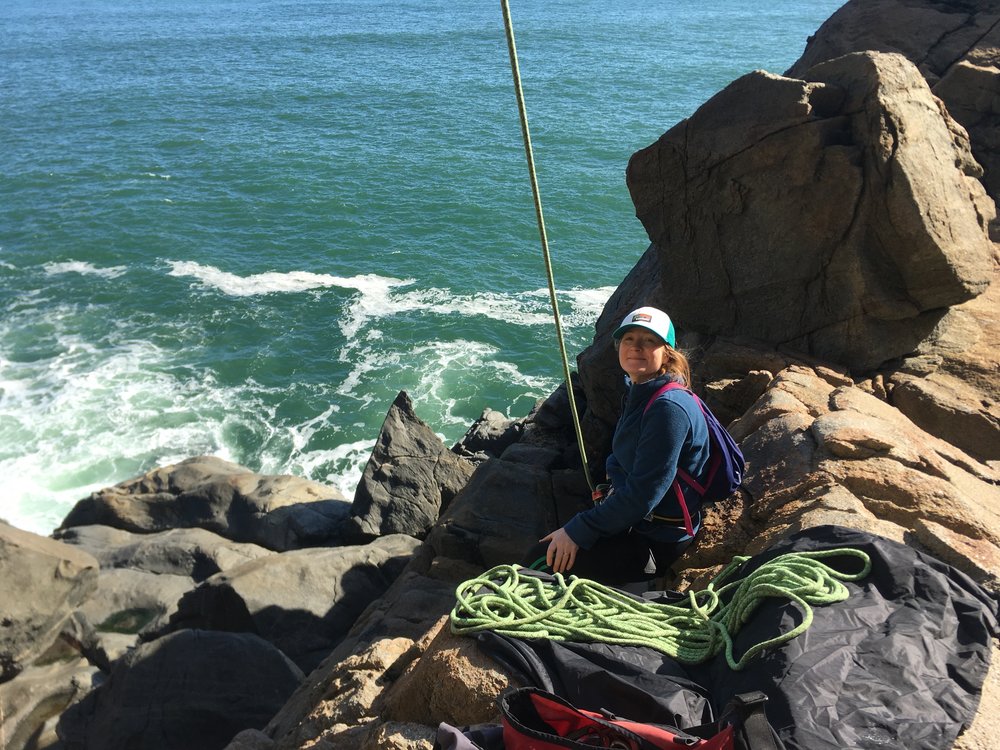 Emily belaying cliffside