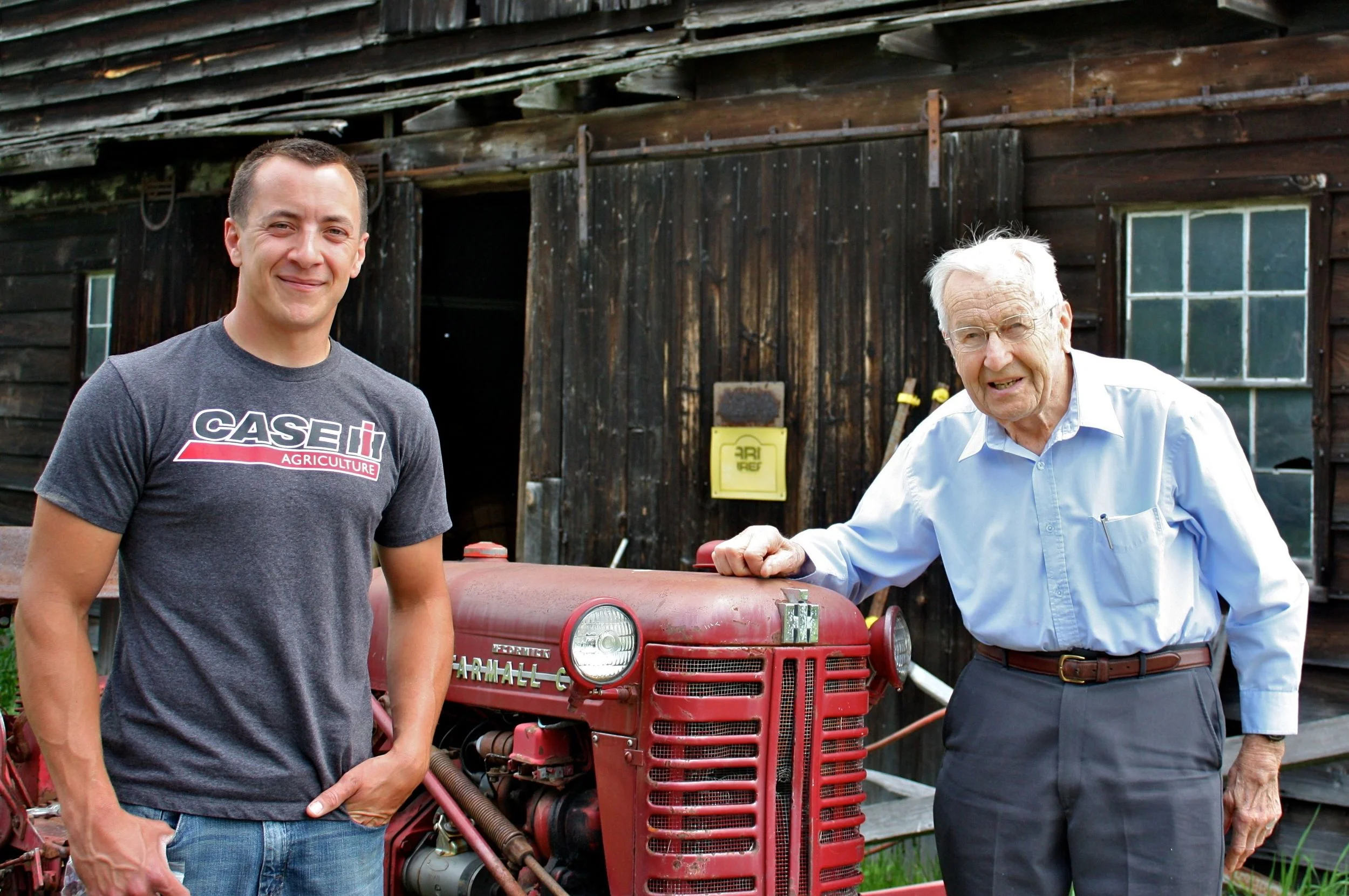 Ev and his grandson Tim in front of their antique Farmall tractor