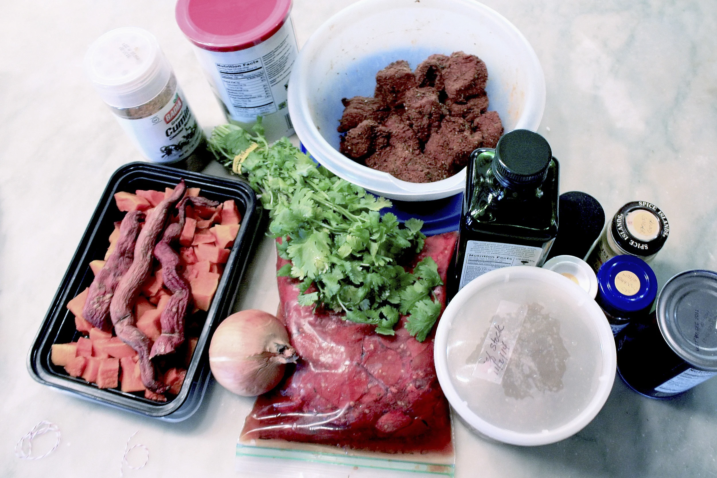 The meat's been marinating for hours. The tomatoes have thawed and we're ready to go. BTW the long squiggly things in the squash box are fingerling sweet potatoes. Not one of nature's better ideas.