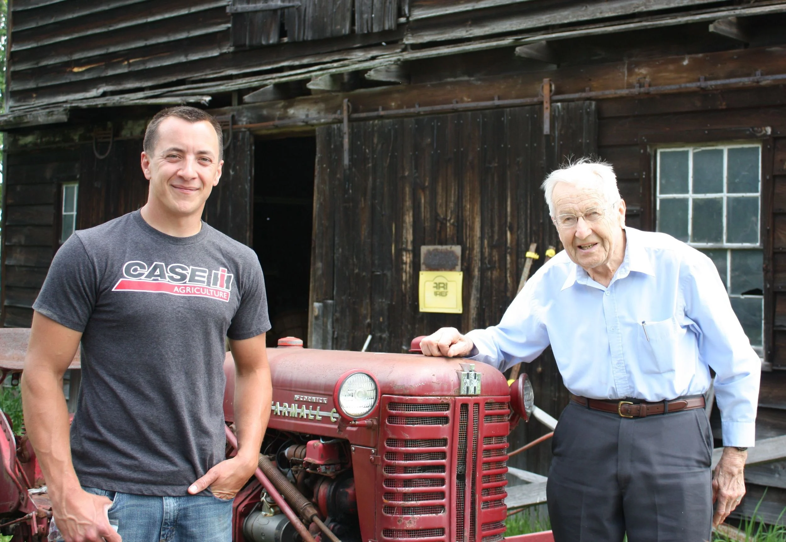 Tim Rau with his grandfather, Everett, in in front of one of their historic Dutch barns.