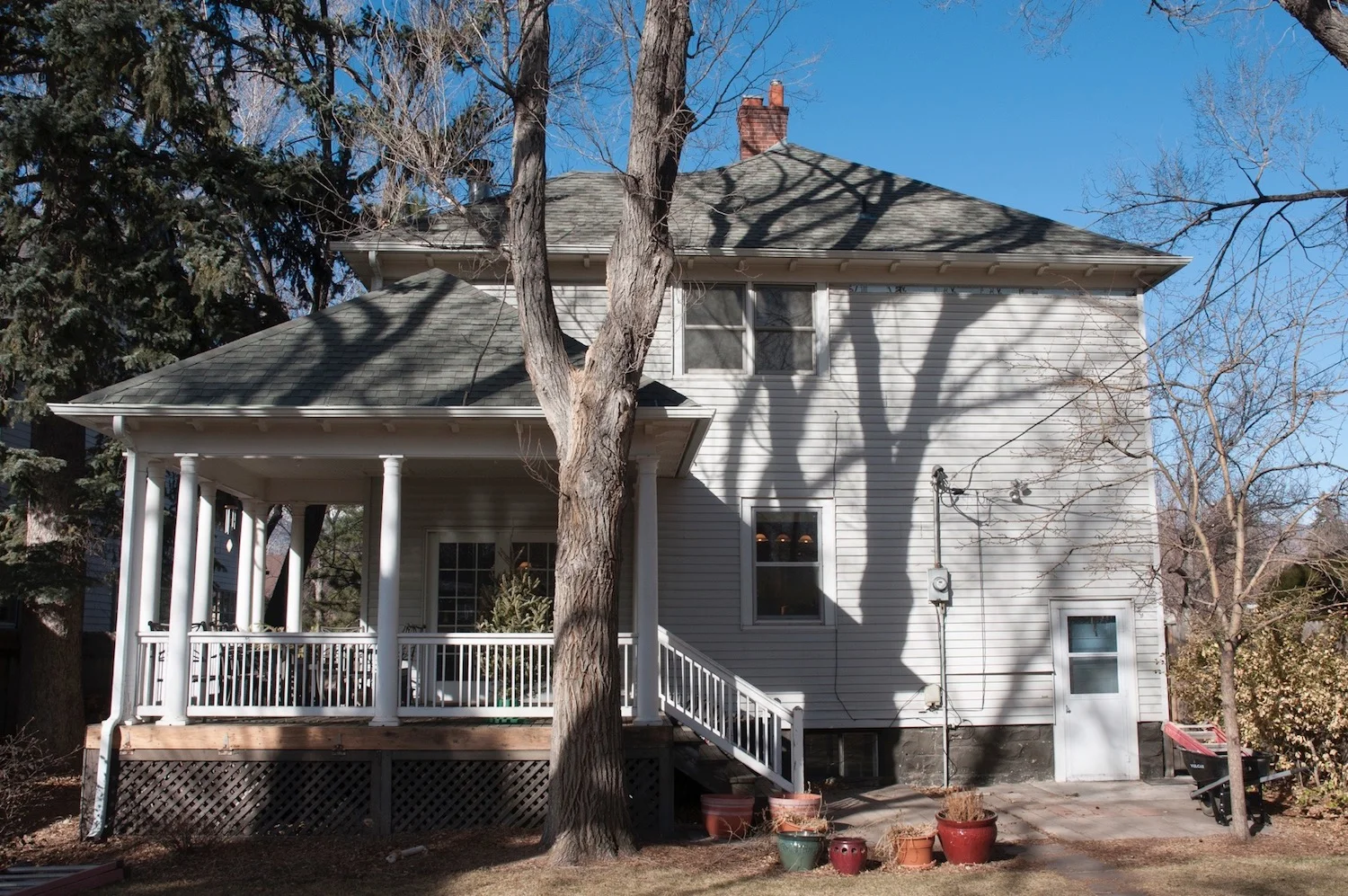Before: Vinyl siding and inconveniently placed electric service detract from a well detailed existing back porch