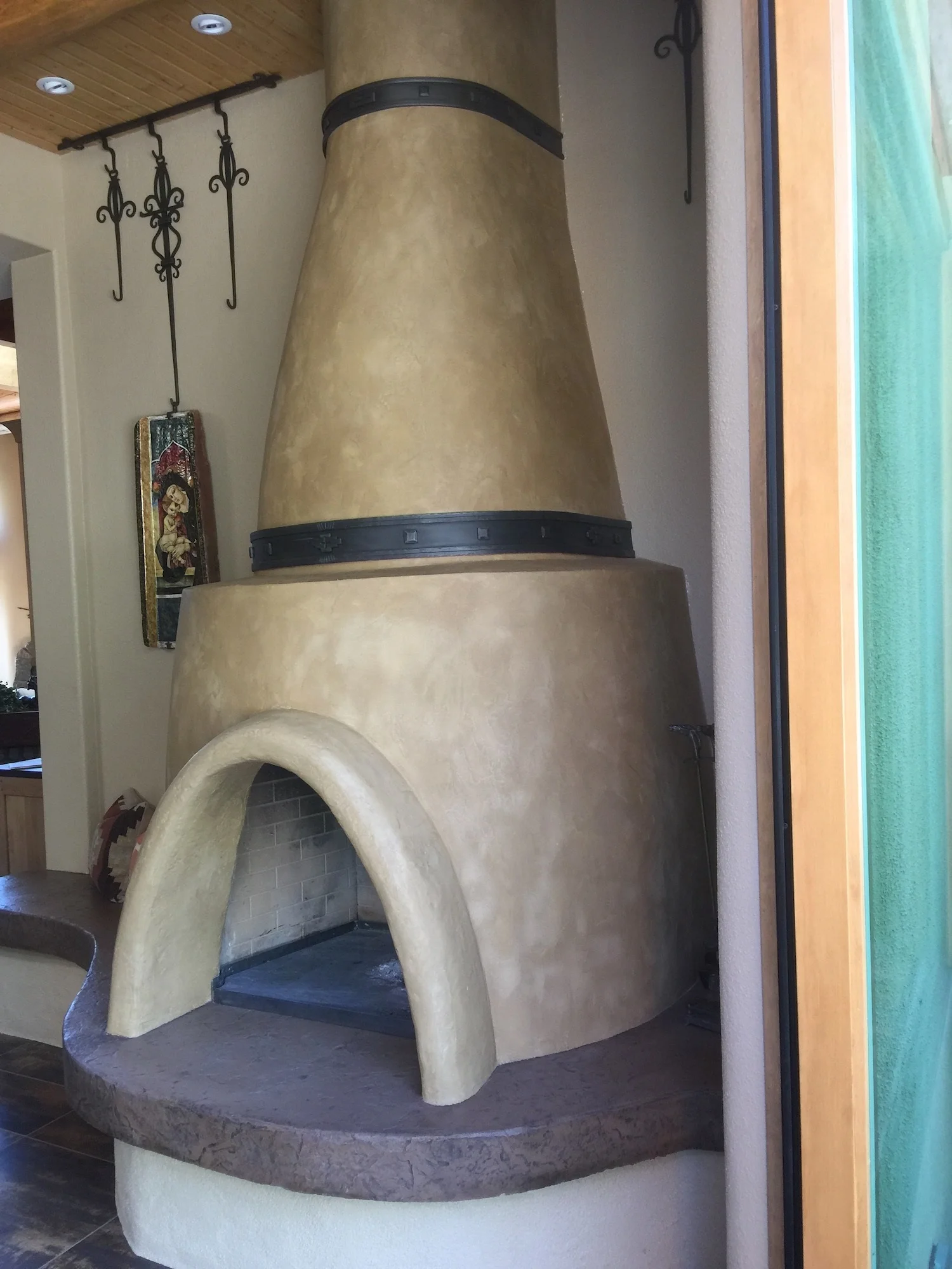 Kiva fireplace- masonry, clay plaster, hand forged iron, cast in place concrete hearth