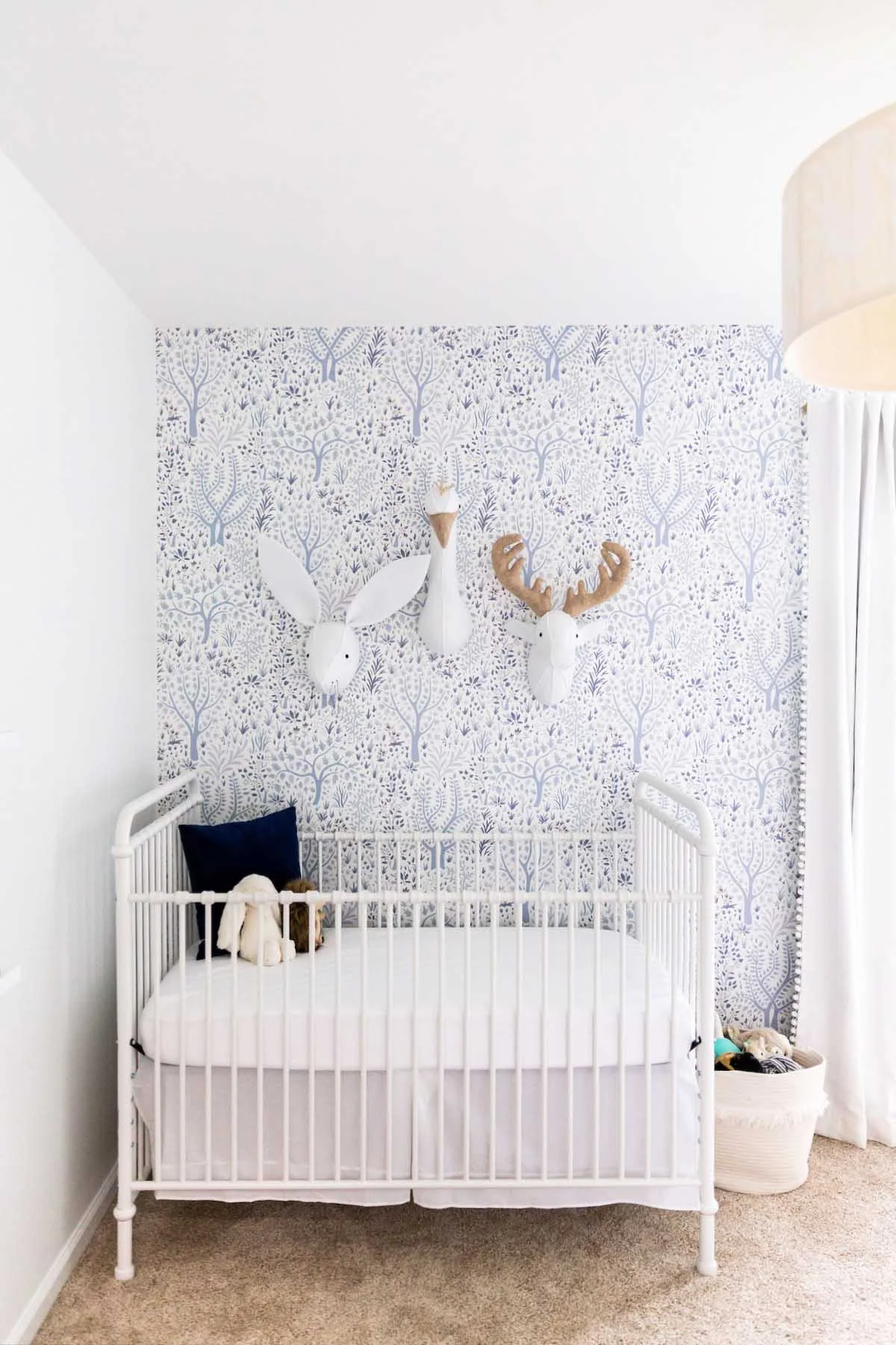 white iron crib in baby nursery with wallpaper