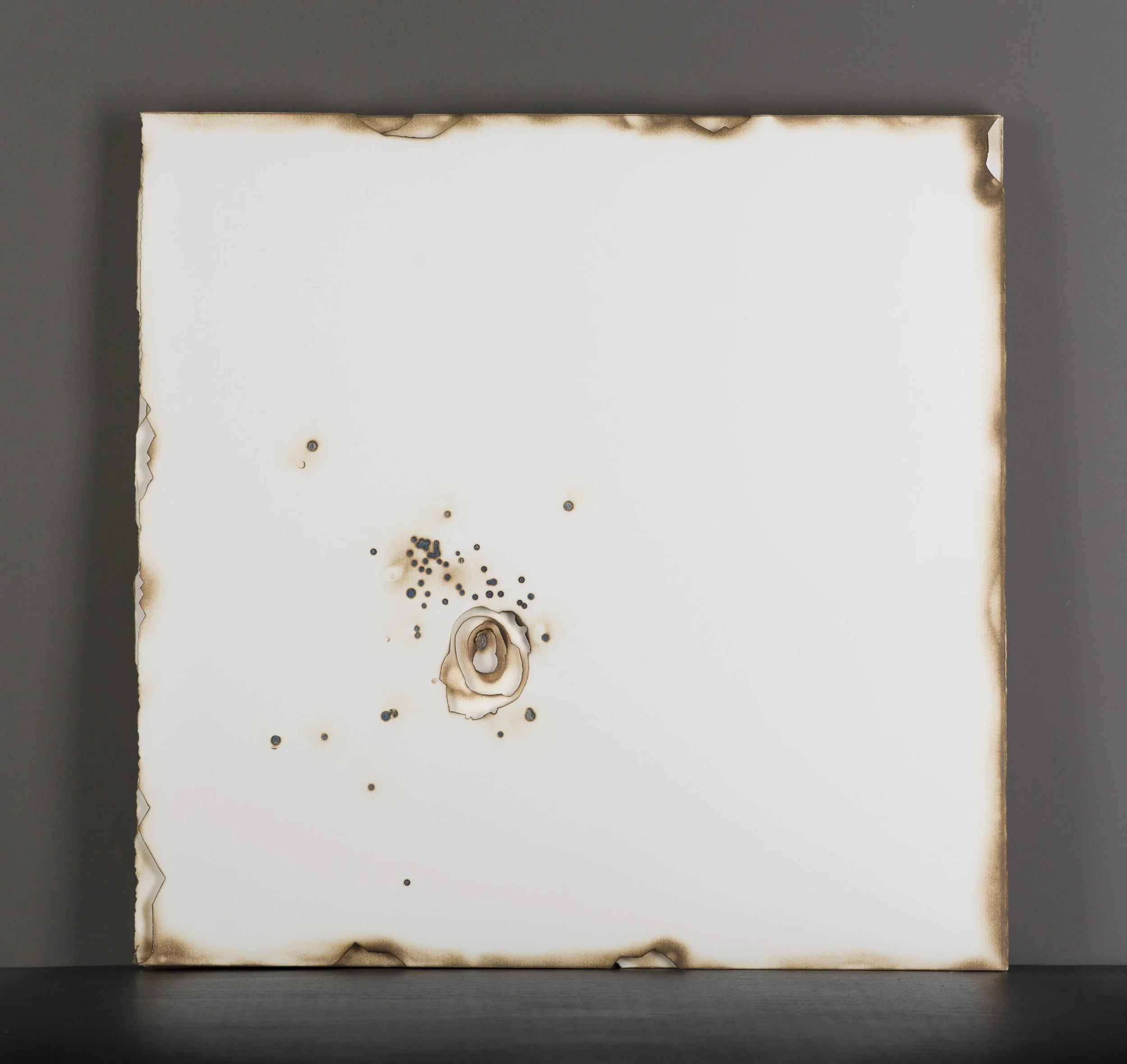Kelly M. O'Brien, Playing With Fire No. 63 . Paper, gold leaf, flame. 20 x 20 x 1.25 inches. ©2017. One of a set of a four-piece series commissioned for Kimpton The Rowan Palm Springs, Jasper Boardroom. ©2017.