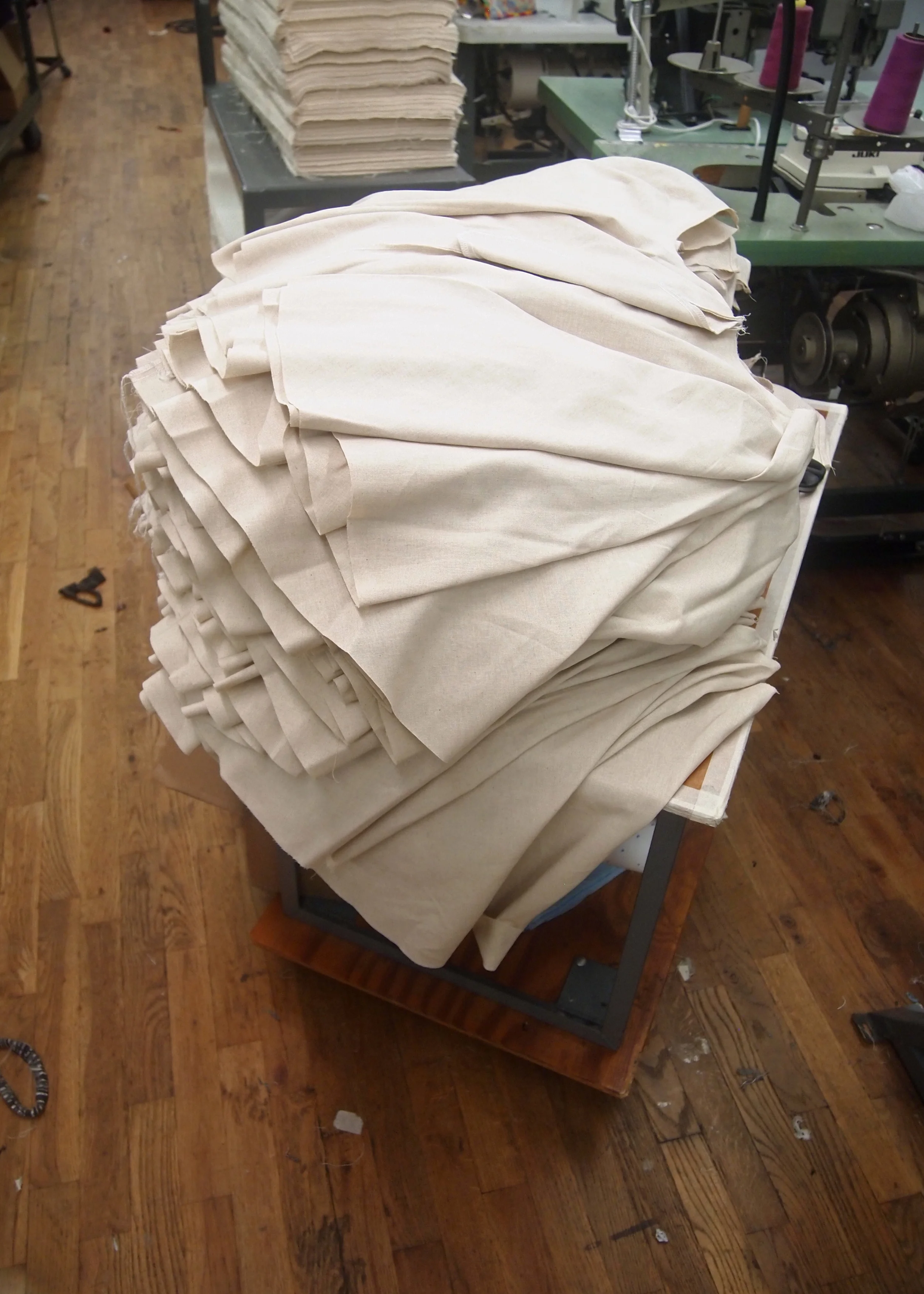 A stack of sewn skirt pieces awaits waistband attachment.