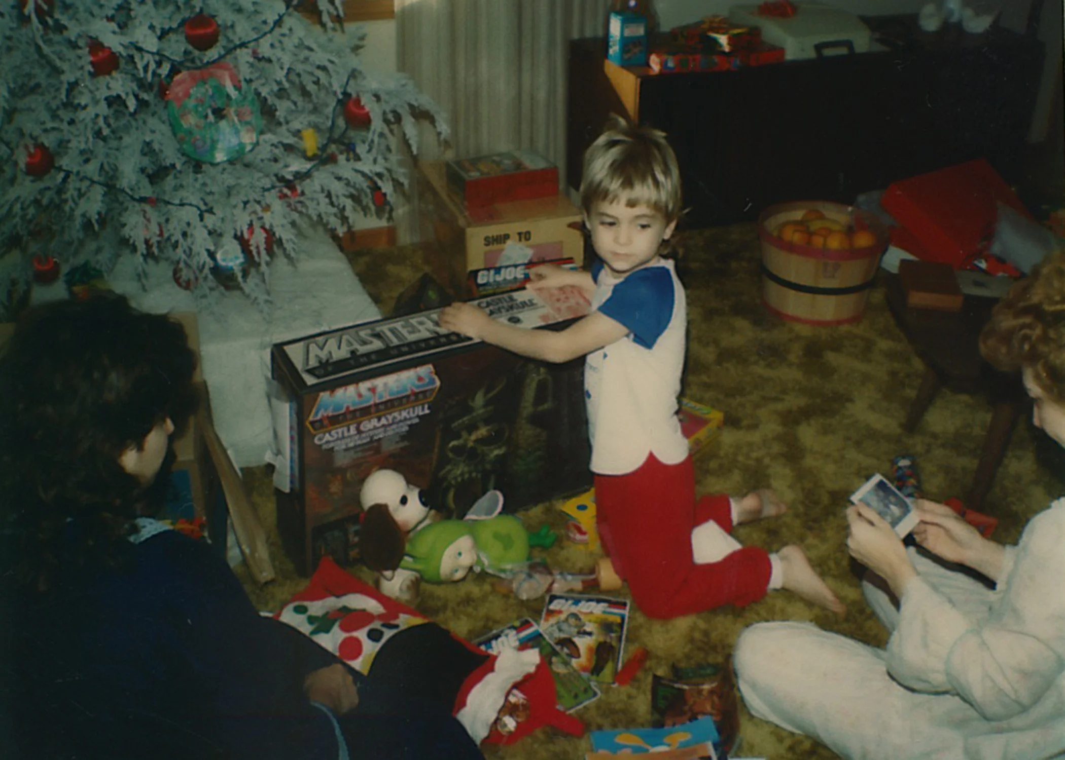 Opening presents with his mom and grandmother. 