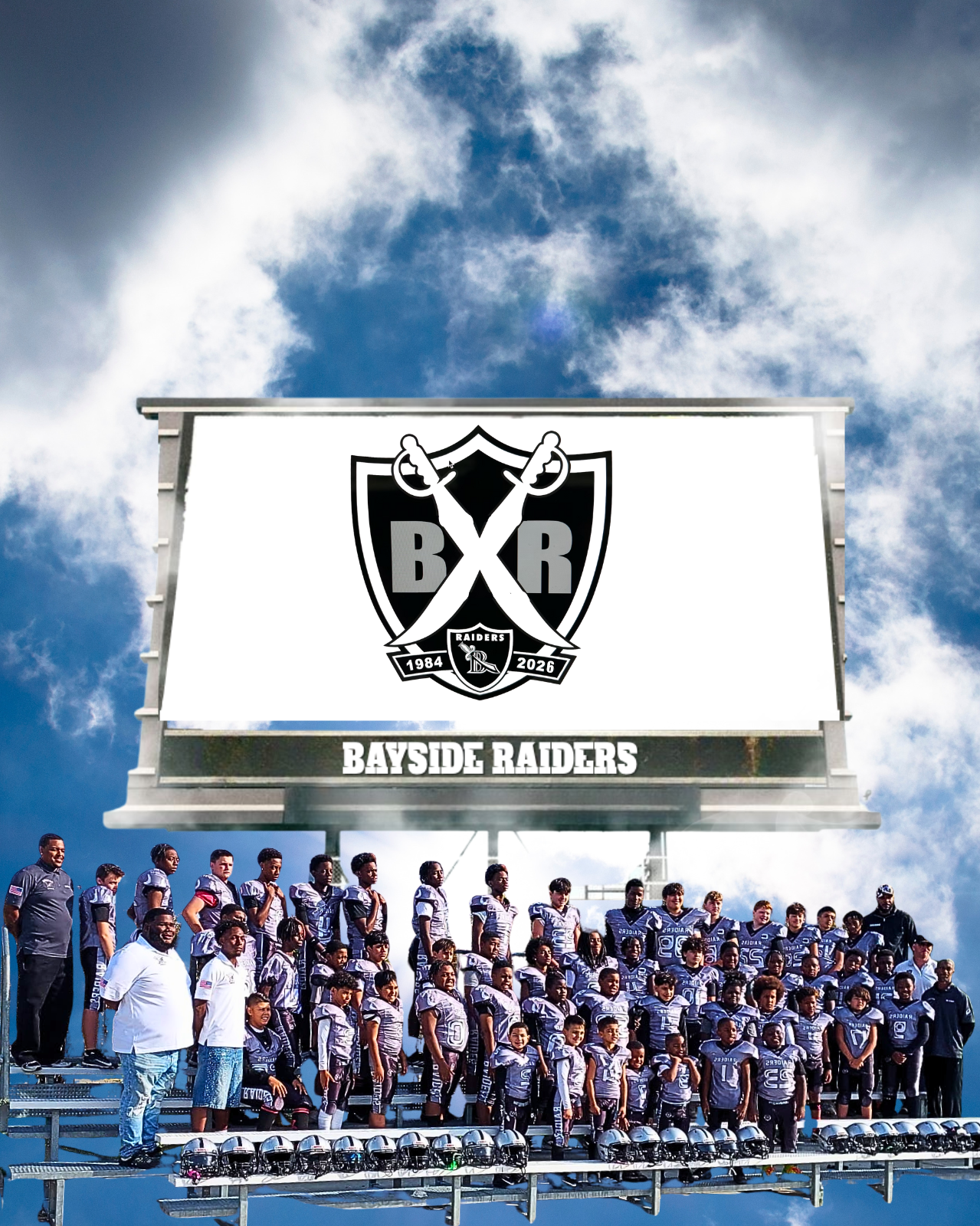 A large football team photo of young players and coaches in football uniforms and gear, standing on bleachers under a bright blue sky with clouds. A billboard above displays the Bayside Raiders logo with crossed swords, a shield, and the years 1984 to 2026.
