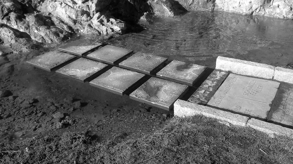 als brücke dienen schwebende schiefersteine um den wassergraben zu queren