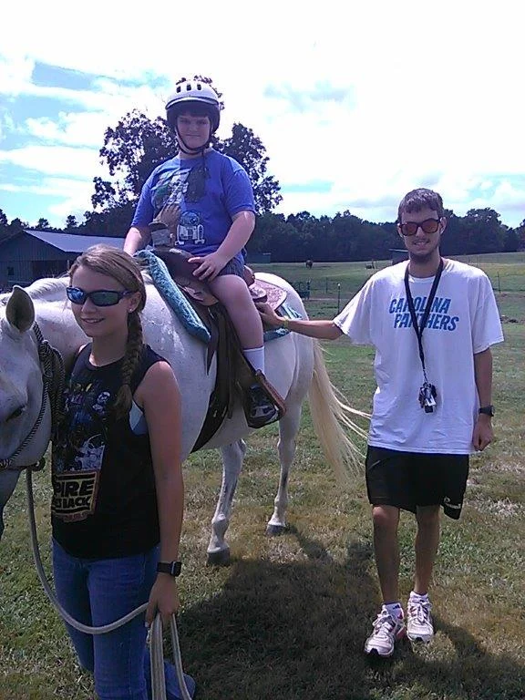 Paul at age 20 volunteering as a sidewalker during a therapeutic riding session.
