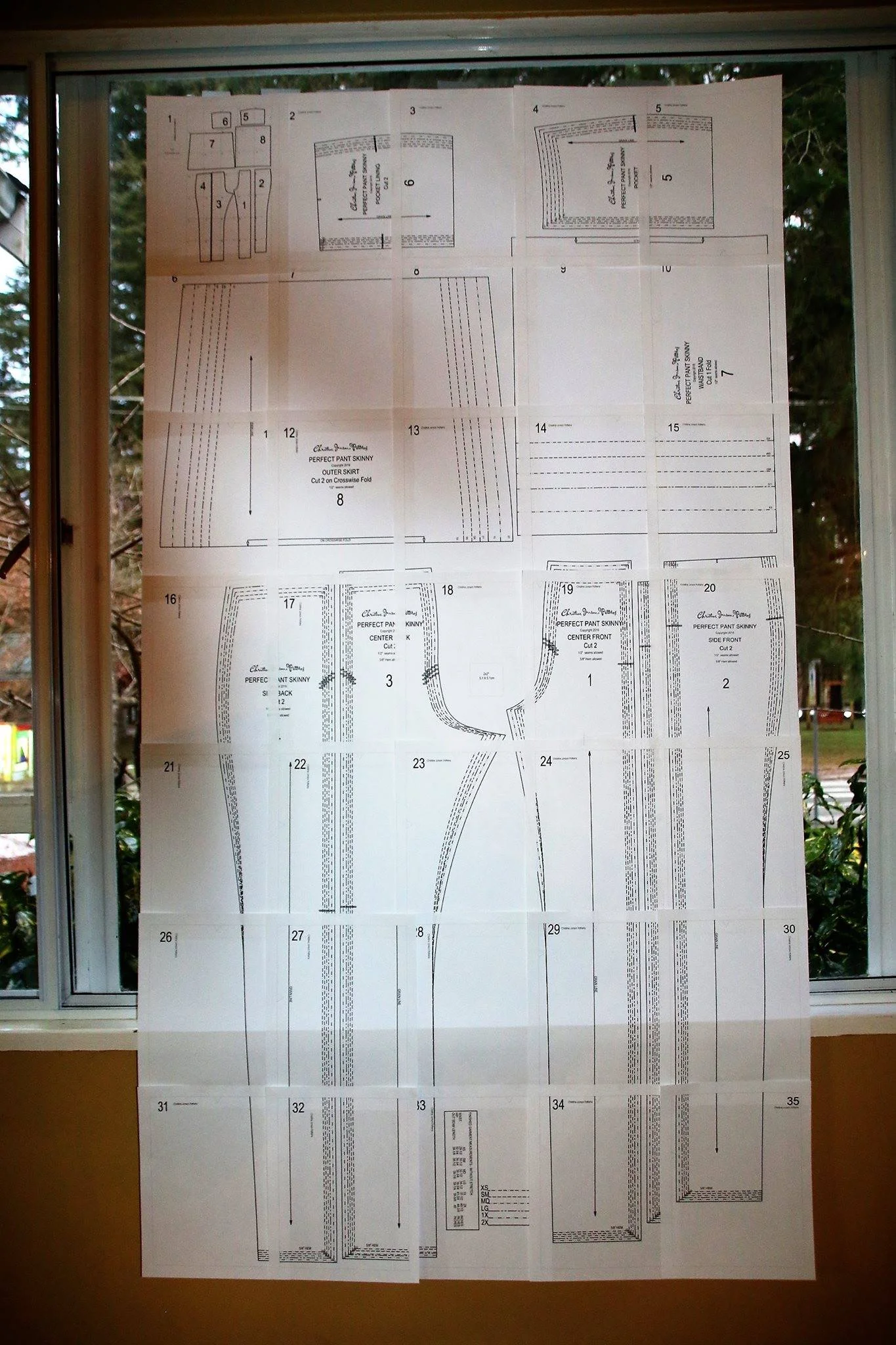 Downloadable sewing patterns like the Perfect Pants, shown here, can easily be printed, matched and taped up even if your printer cuts off one of the borders. Putting it up on your window or glass door like this is an easy way to see how the pattern lines up as you tape.