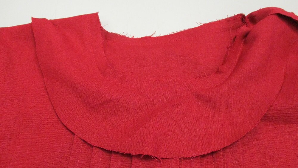  With right sides together, match neckline with facing and stitch together.  