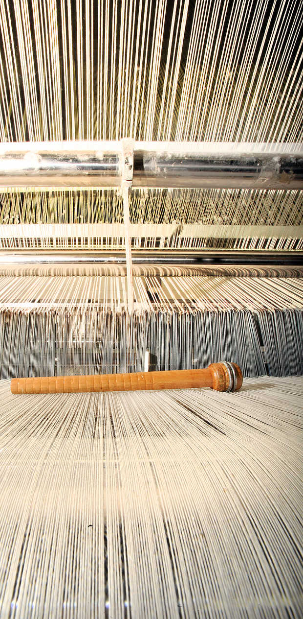 An old wooden bobbin (they are now made of cardboard) used by weavers to help pull thread into place rests on a loom for easy access at Maine Heritage Weavers in Lewiston. | RUSS DILLINGHAM/SUN JOURNAL