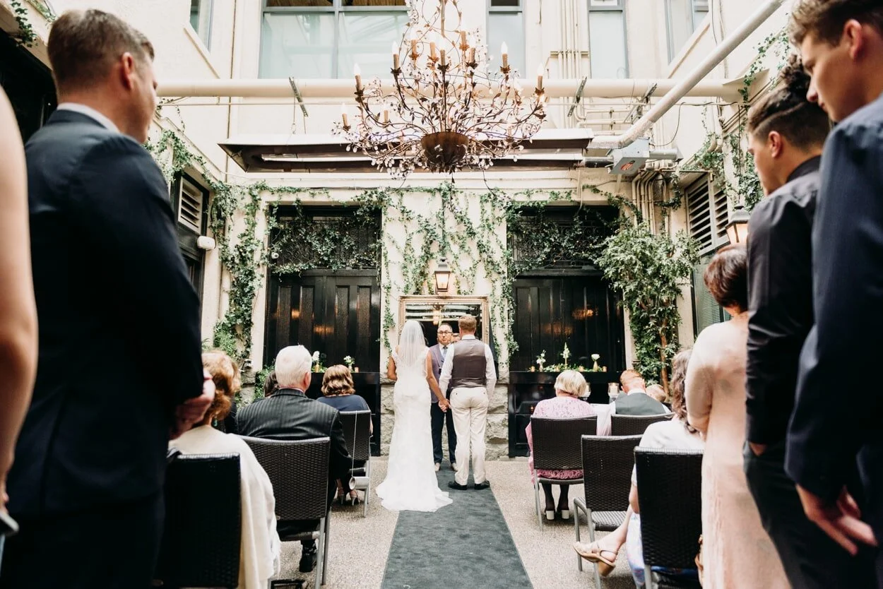 Bride and groom standing at end of aisle during wedding ceremony