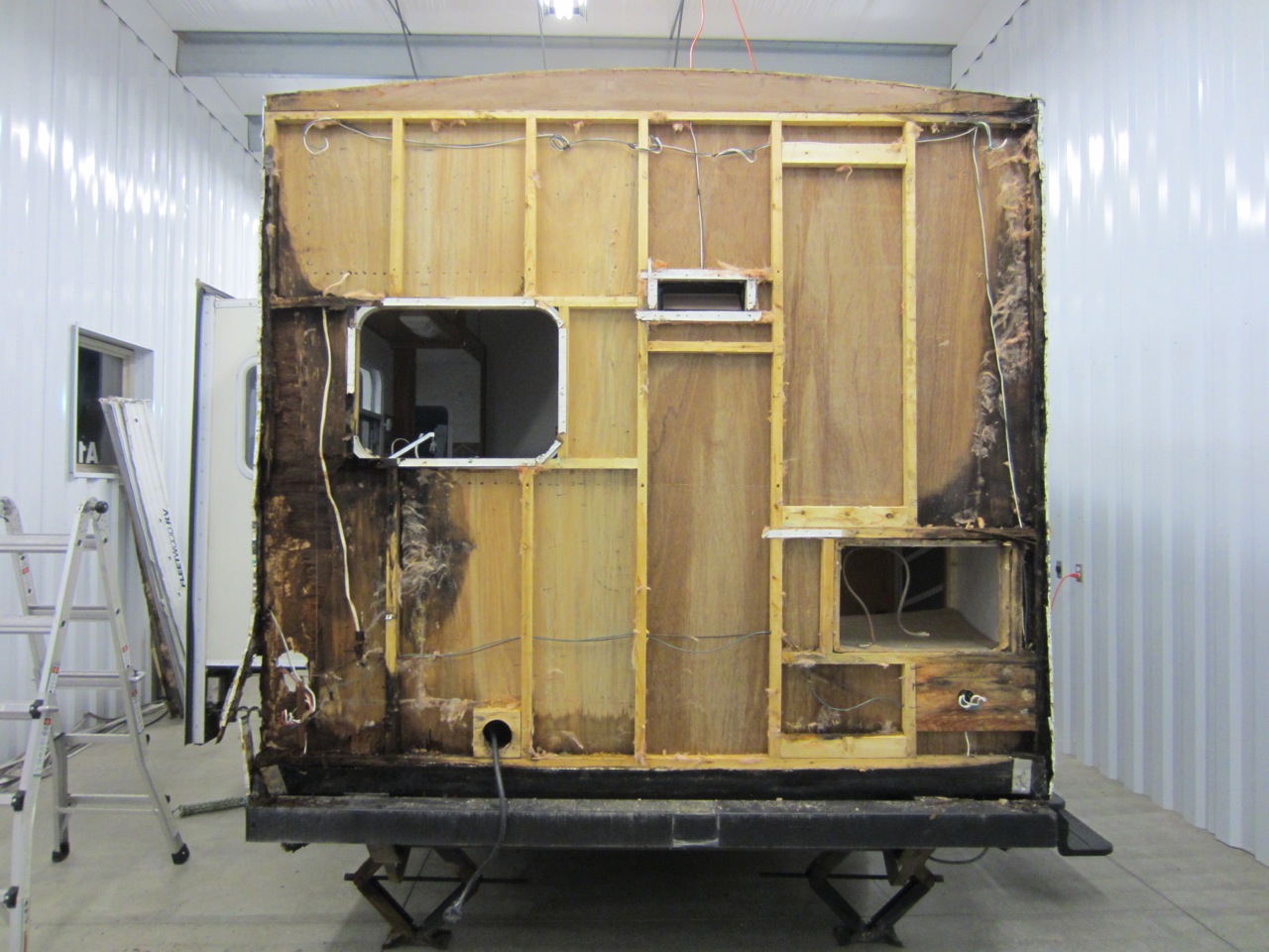  And THIS was our big, ugly surprise - the back of the RV  also &nbsp;has water damage!&nbsp;View of the back with the insulation removed. All the black wood is rotted wood. 