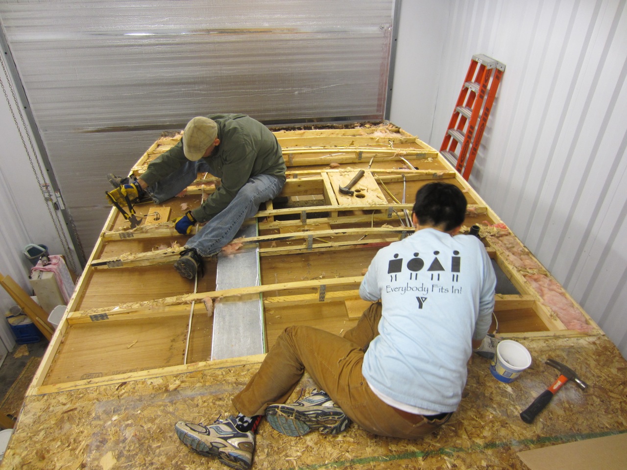  Steps to removing the roof: 1) Pull the wood off using a pry bar and brute strength (it's glued and stapled down tightly). 2) Remove the insulation (we packed it up for later use). 3) Remove all the staples left behind. 4) Drink some beer. 5) Repeat