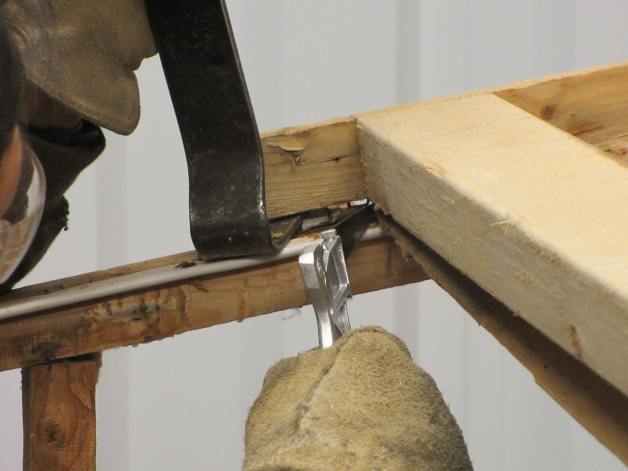 There is luan stapled and sandwiched between the roof beams that we had to remove using a pry bar and small hand saw.