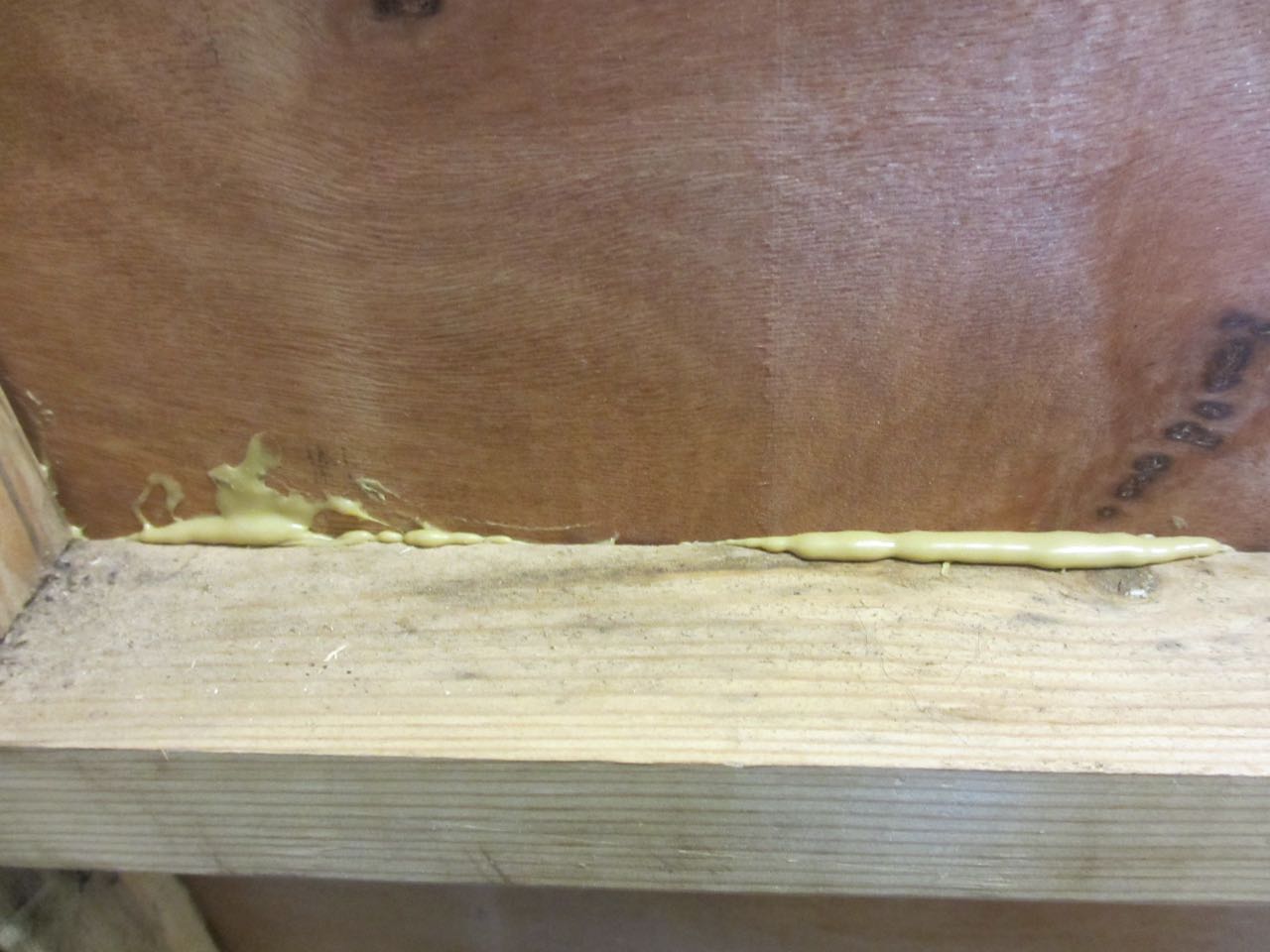 We squirted Liquid Nails on the kitchen beams and placed the luan on it.