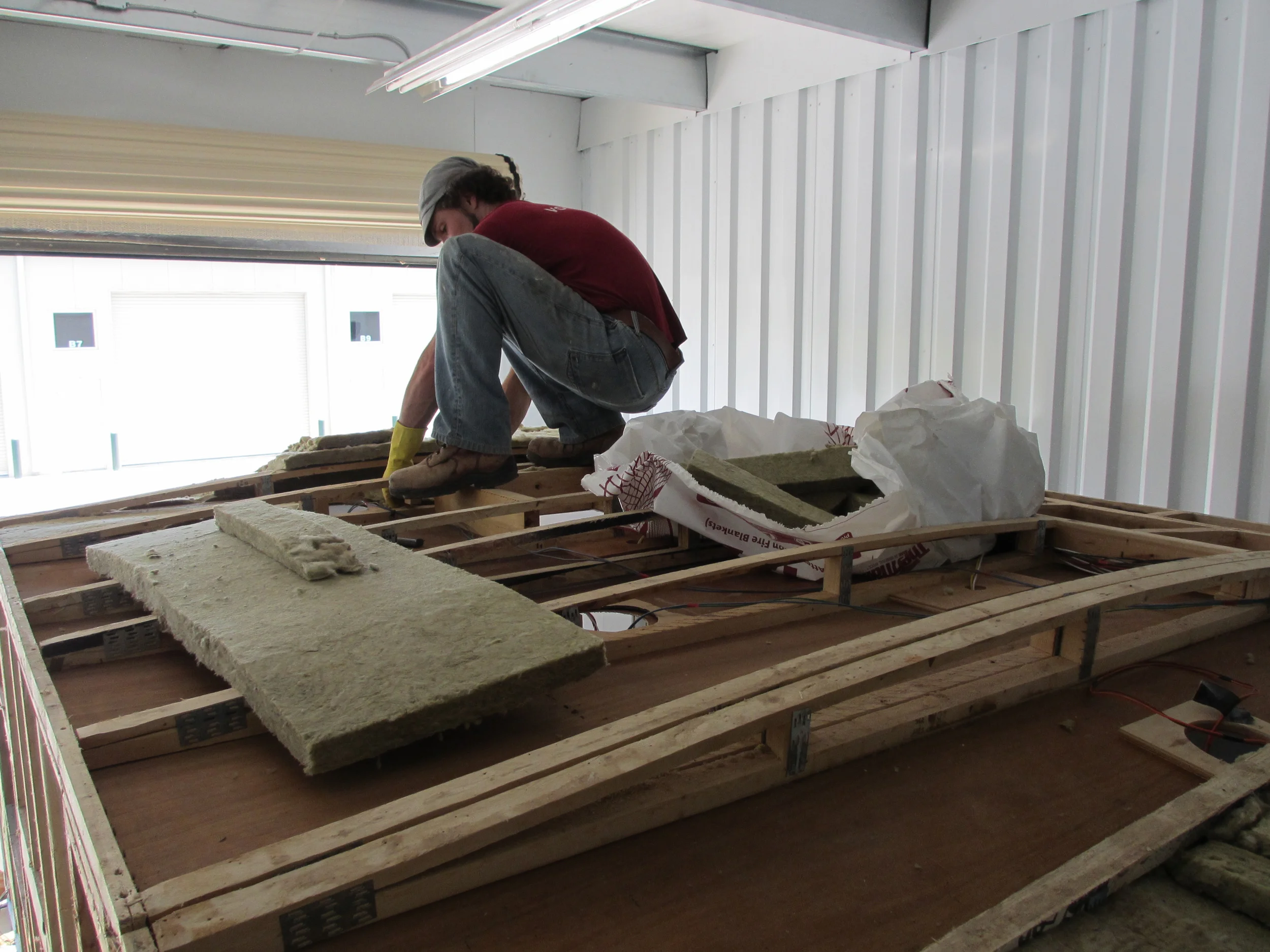 Jerud placing the cut insulation in the roof.
