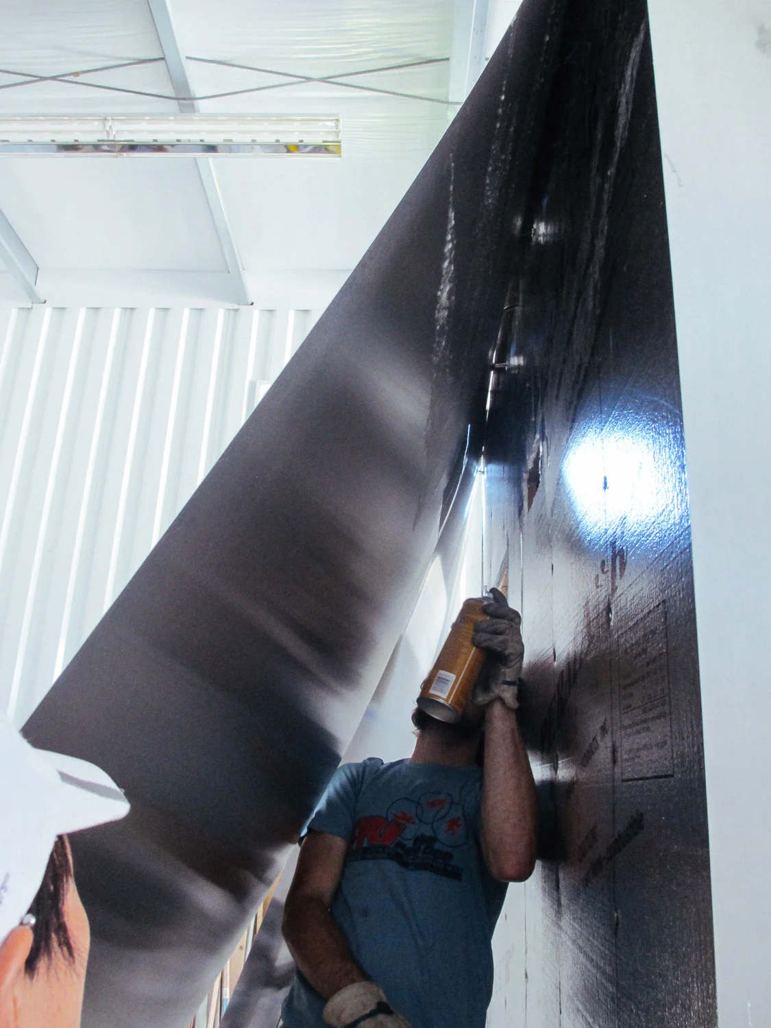 Adhesive was sprayed on the back of the aluminum sheets to attach to the foam insulation boards.