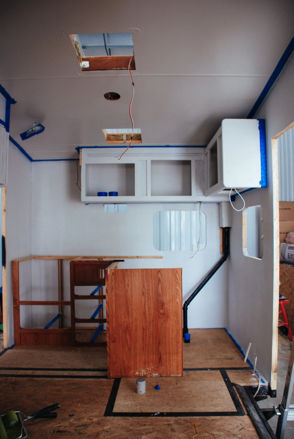 New subfloors were installed, kitchen walls primed, and upper cabinets painted.