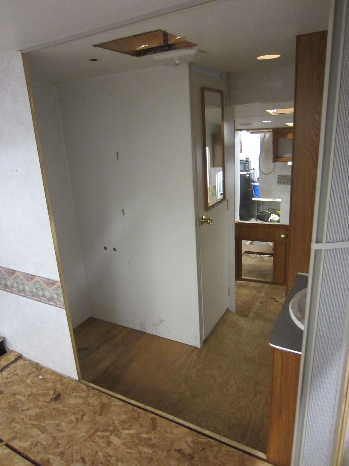  This is what the bathroom area used to look like. The shower was separated from the bedroom by a protruding wall on the left. An accordion door by the sink separated the sleeping and bathroom areas, and there was a door to the toilet. 
