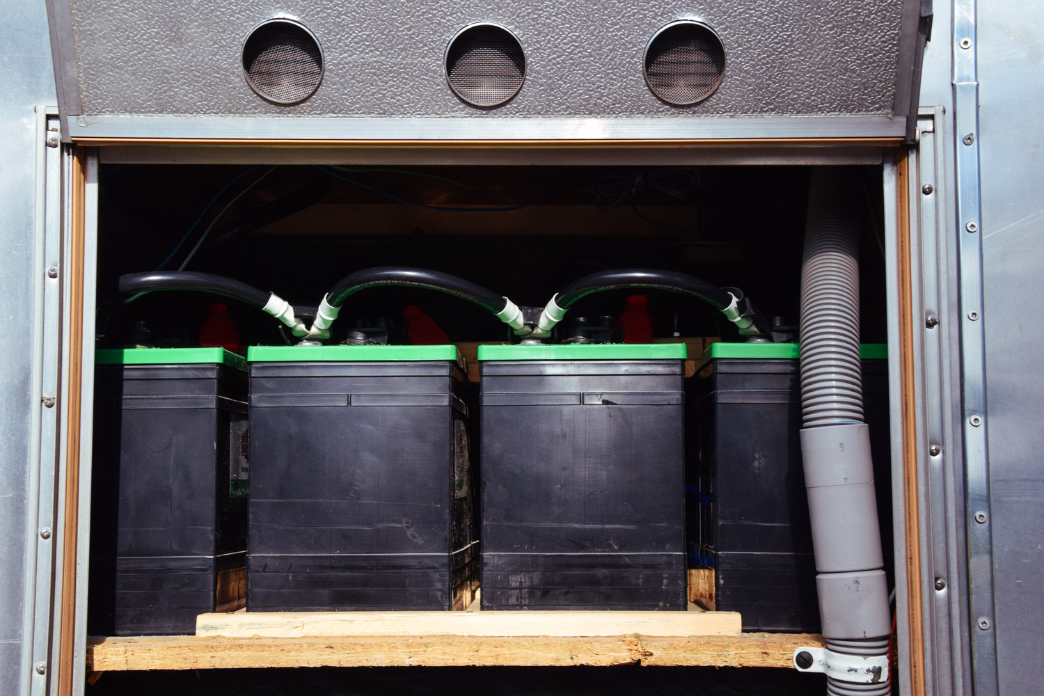  The composting toilet vent pipe exits the bathroom floor, through the battery compartment (gray pipe), and out the bottom of the rig.    