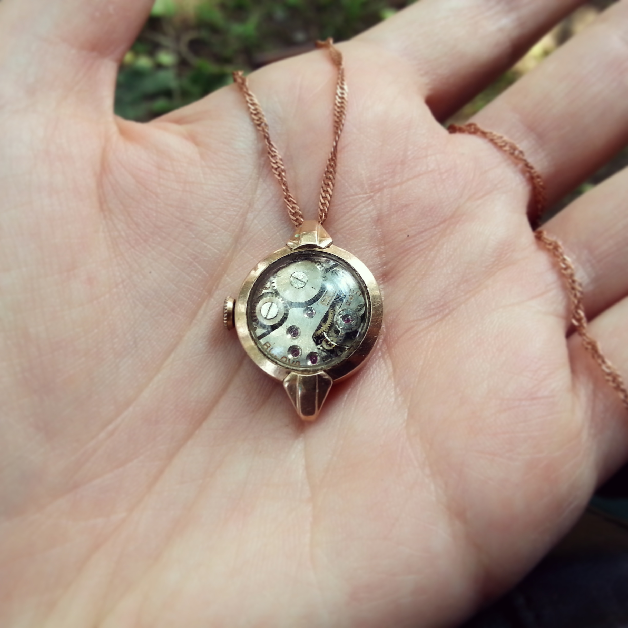 Pendant made using a beautiful 1940's Bulova watch case with exposed movement.