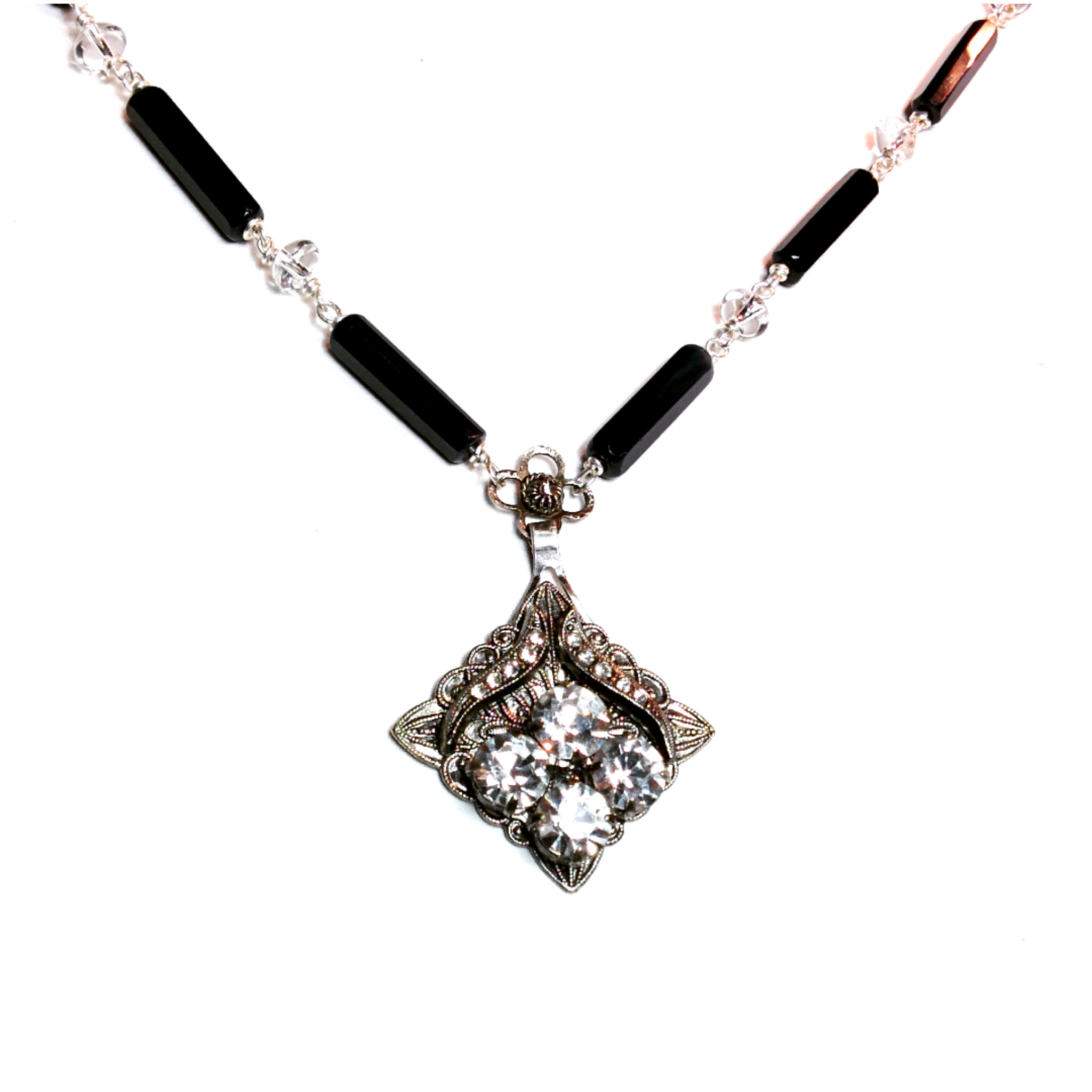 A lovely modified rhinestone treasure with plenty of detail sits on a small vintage flower and a chain made of onyx and crystal quartz
