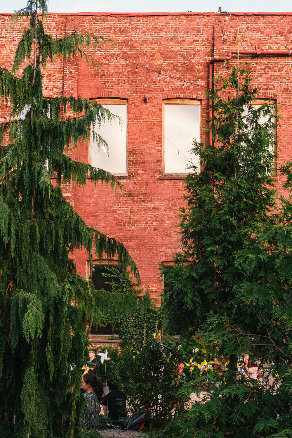  Pinwheels in the Garden with the Pioneer Work warehouse in the background.  #connectiveproject at Pioneer Works 