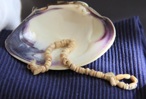 A small strand of 40,000-year-old wampum beads sit in a quahog shell, from which wampum is made. This necklace may be the most impressive piece at the Tomquag Museum.
