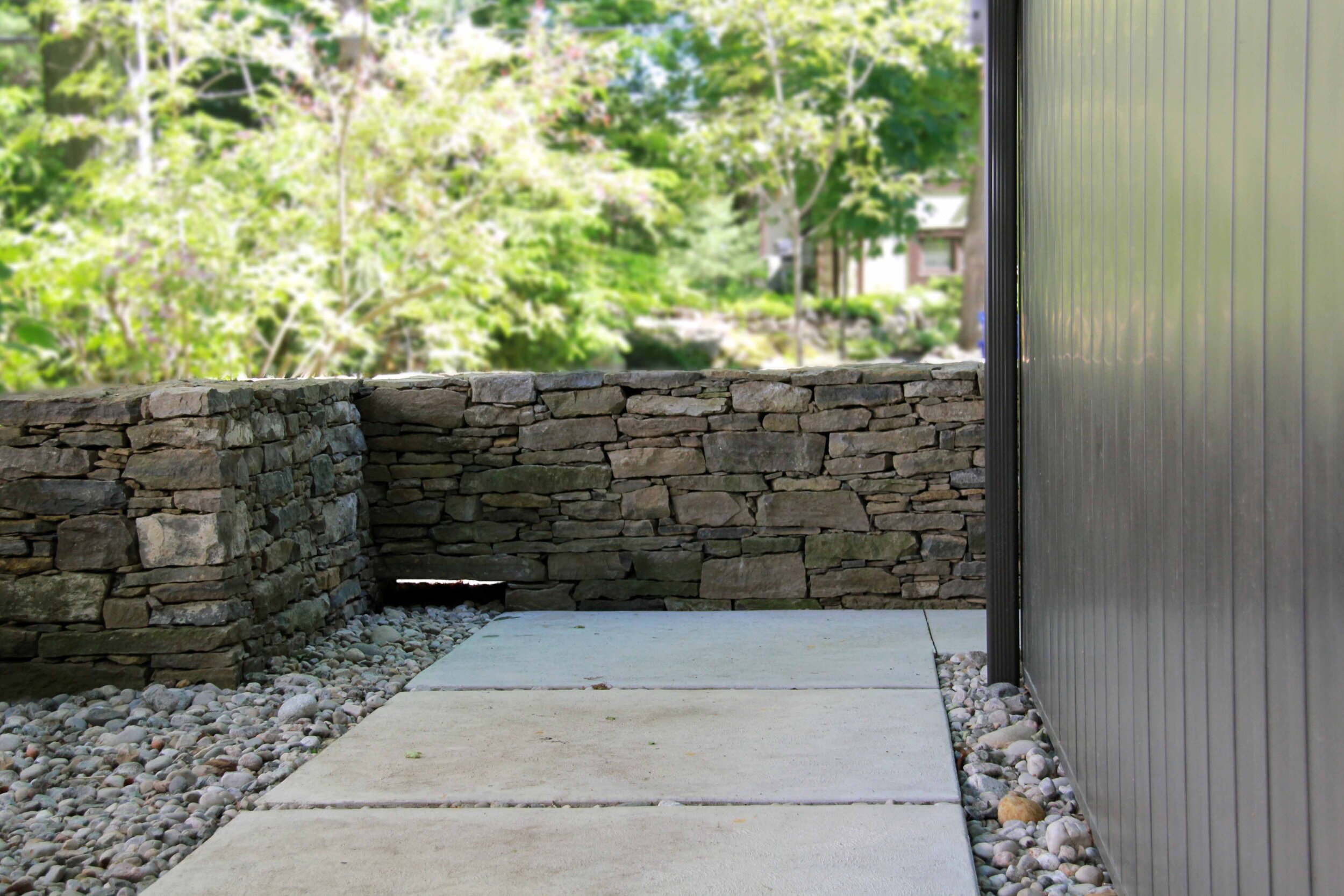 Dry laid stone-Modern home side entrance-Pebble stone-Conrete walway- Natural stone-Stone wall-Drainage-.jpg