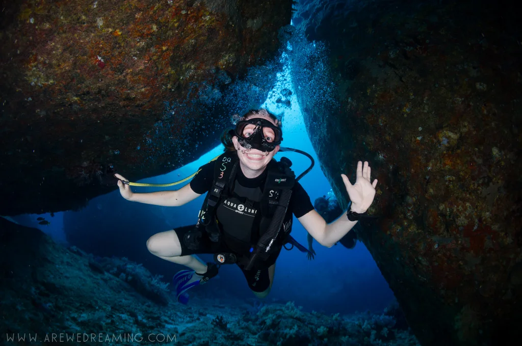 Kelsi diving through rocks in the Similan Islands. From Tom Ozanne at arewedreaming.com