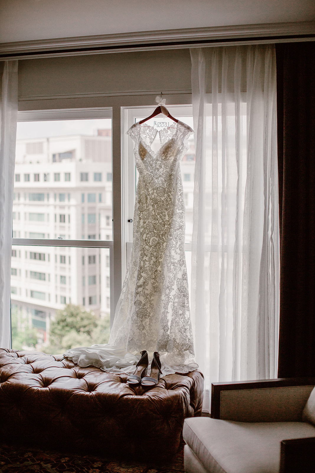  Wedding dress hanging in the window of the hotel room. Bride and groom getting ready at the Phoenix Park Hotel, Washington D.C. Irish wedding with green and gold accents. Sarah Mattozzi Photography. 