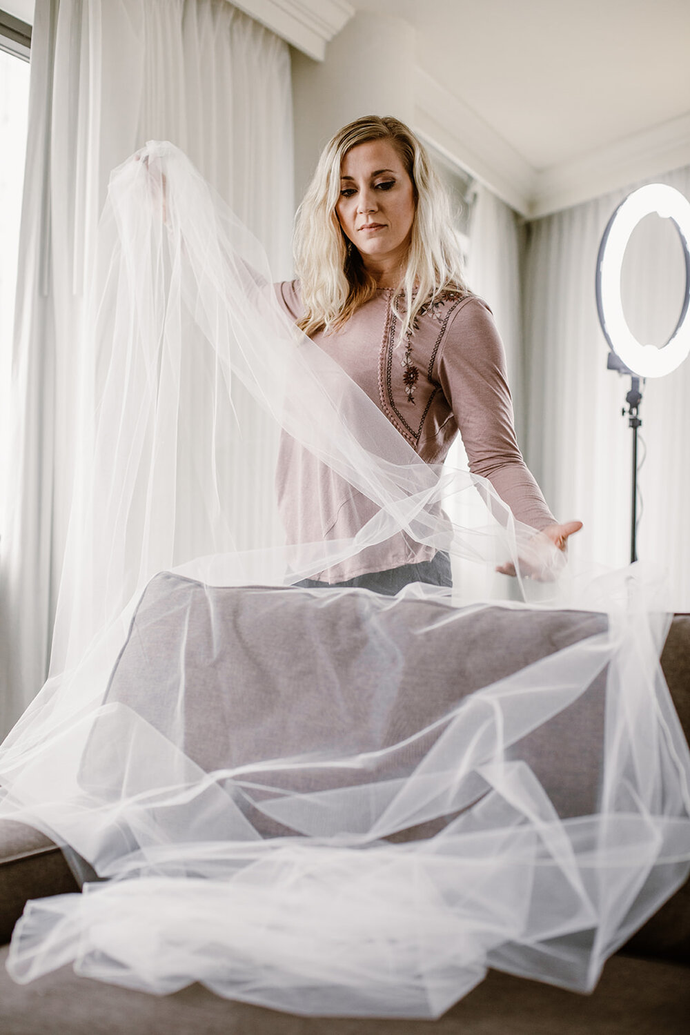  Fluffing a cathedral veil. Wedding party getting ready at The Delta Hotels in Richmond, VA. 