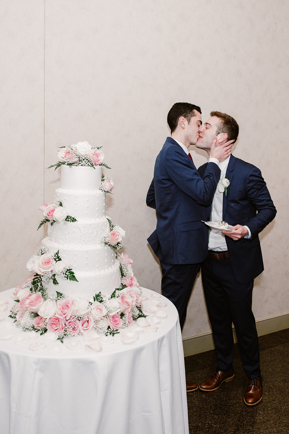  Two grooms cutting the cake. Vegan wedding at the Norfolk Botanical Gardens, Norfolk, VA. Rose garden and plant inspired wedding on the first day of Pride month. Sarah Mattozzi Photography. 