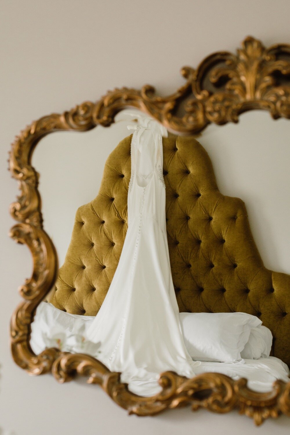  Wedding dress hanging up | Sarah Mattozzi Photography | Black tie wedding at The Historic Cavalier Hotel, Virginia Beach | Tropical, elegant wedding inspiration, black tux groom, glam bride, greenery bouquets, sentimental, classic, minimalist weddin