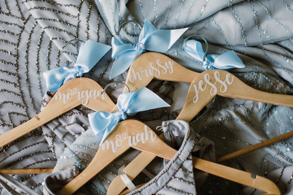  Custom wedding hangers with names | Sarah Mattozzi Photography | Black tie wedding at The Historic Cavalier Hotel, Virginia Beach | Tropical, elegant wedding inspiration, black tux groom, glam bride, greenery bouquets, sentimental, classic, minimali