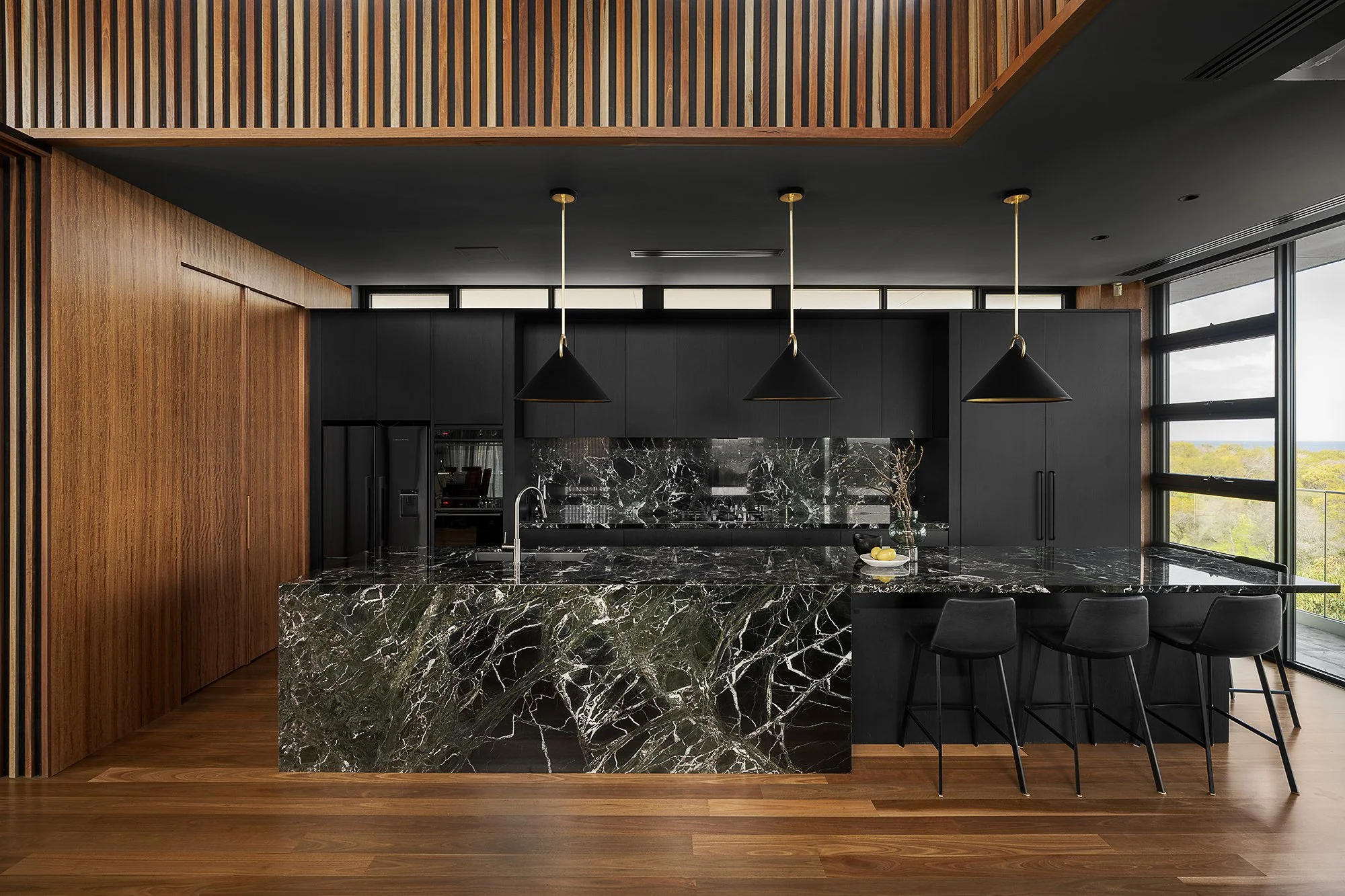 lack veneer with Verde Ricca marble to give the home a kitchen that matches the scale of its architecture.
