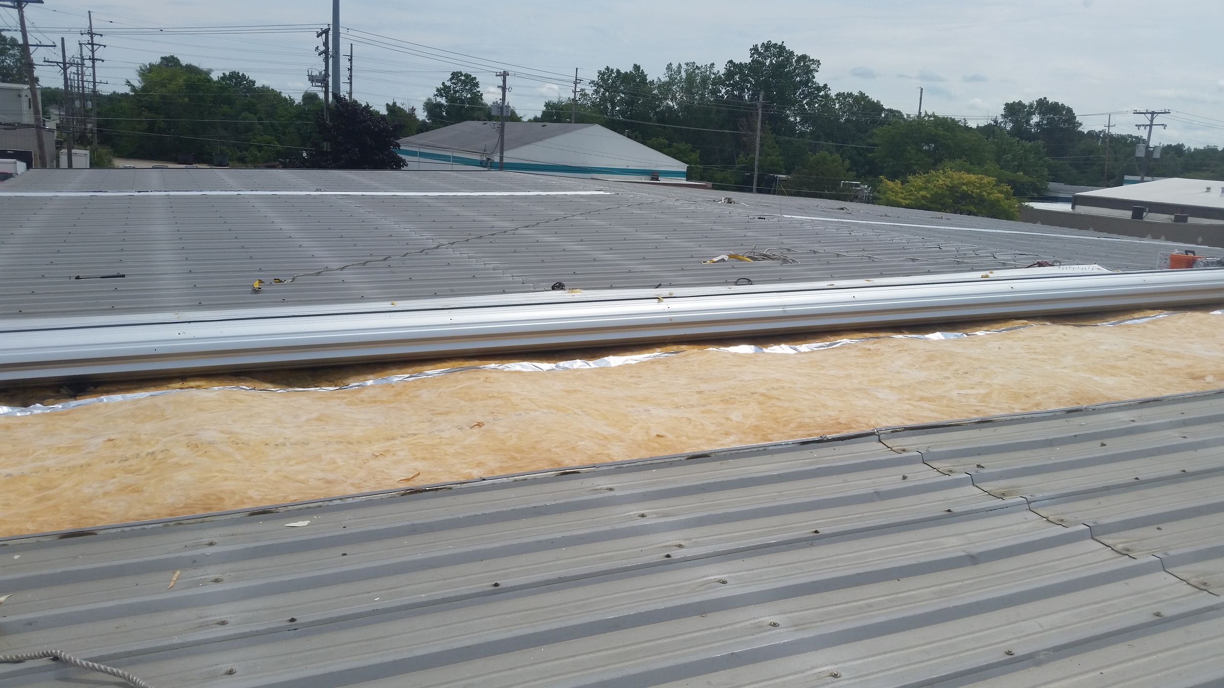Metal building insulation replacement, view from the roof. New insulation has been installed. Lapel MI, August 2016