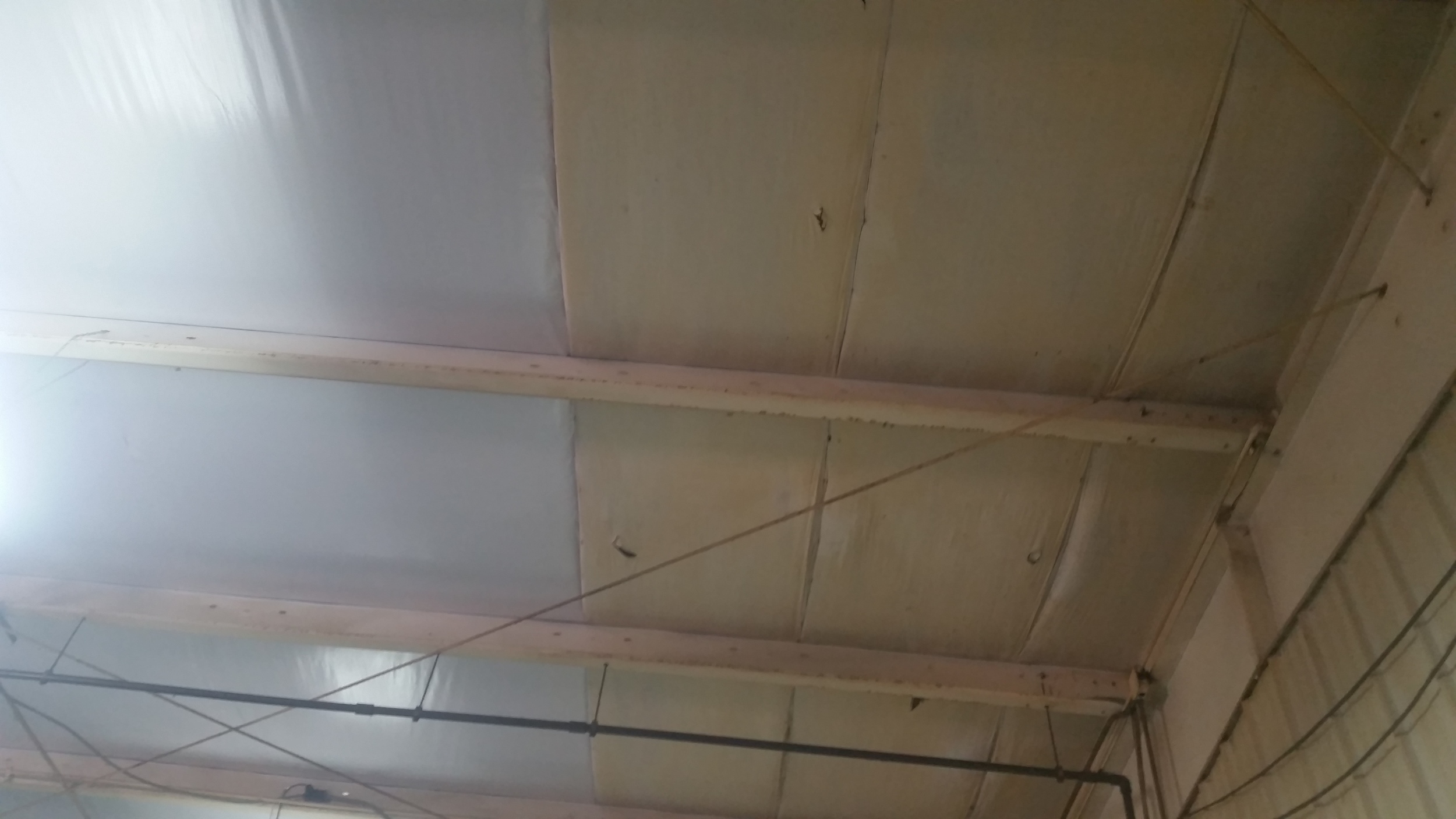 View from inside the building, insulation change-out / replacement, side by side. The new insulation is so bright its hard to capture a good picture.