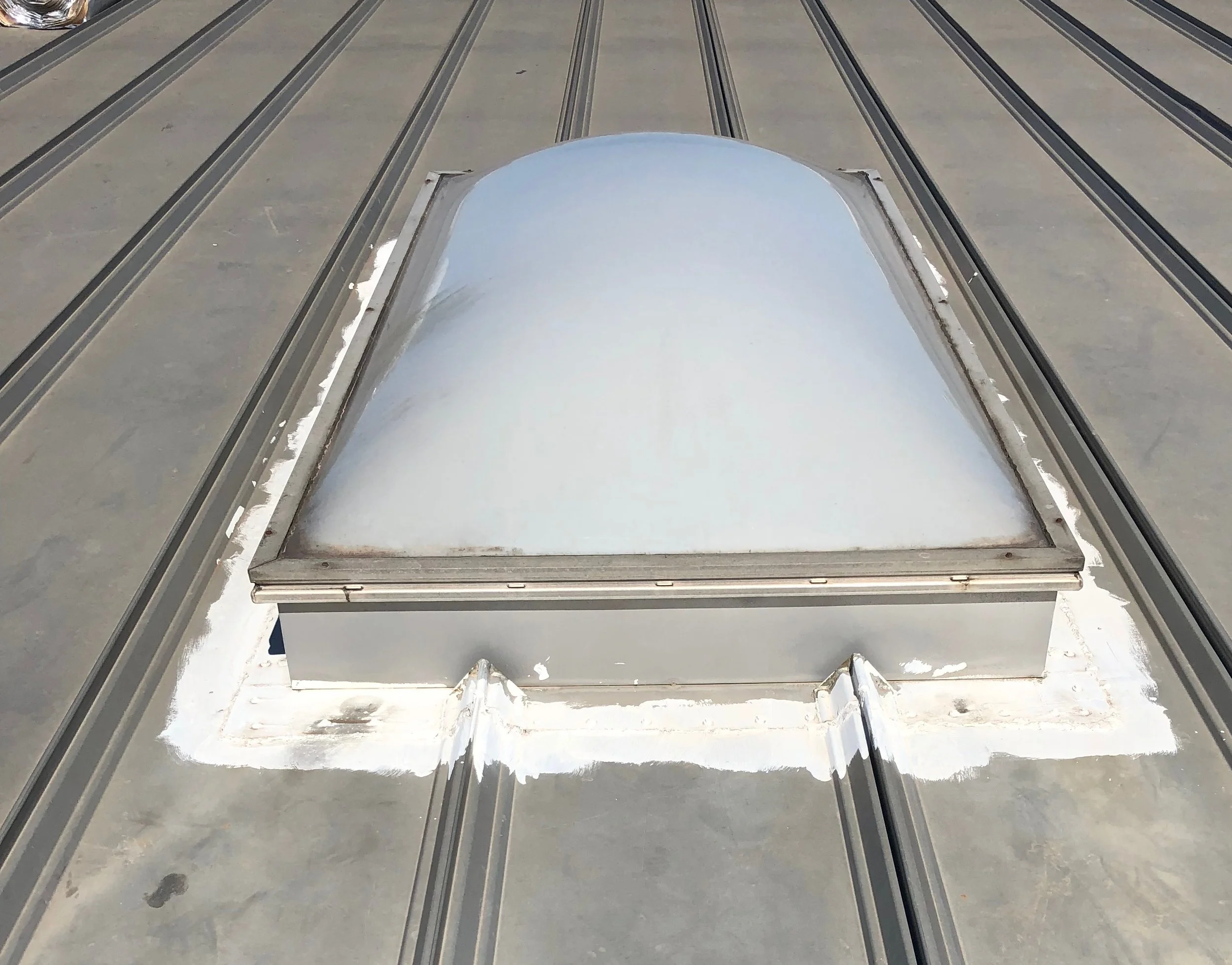 Before, a metal roof skylight the building owner wanted removed.